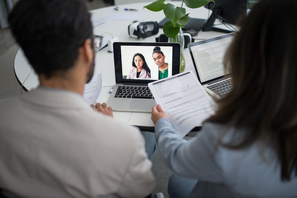 Bewerber in der Webcam mit Fragenkatalog