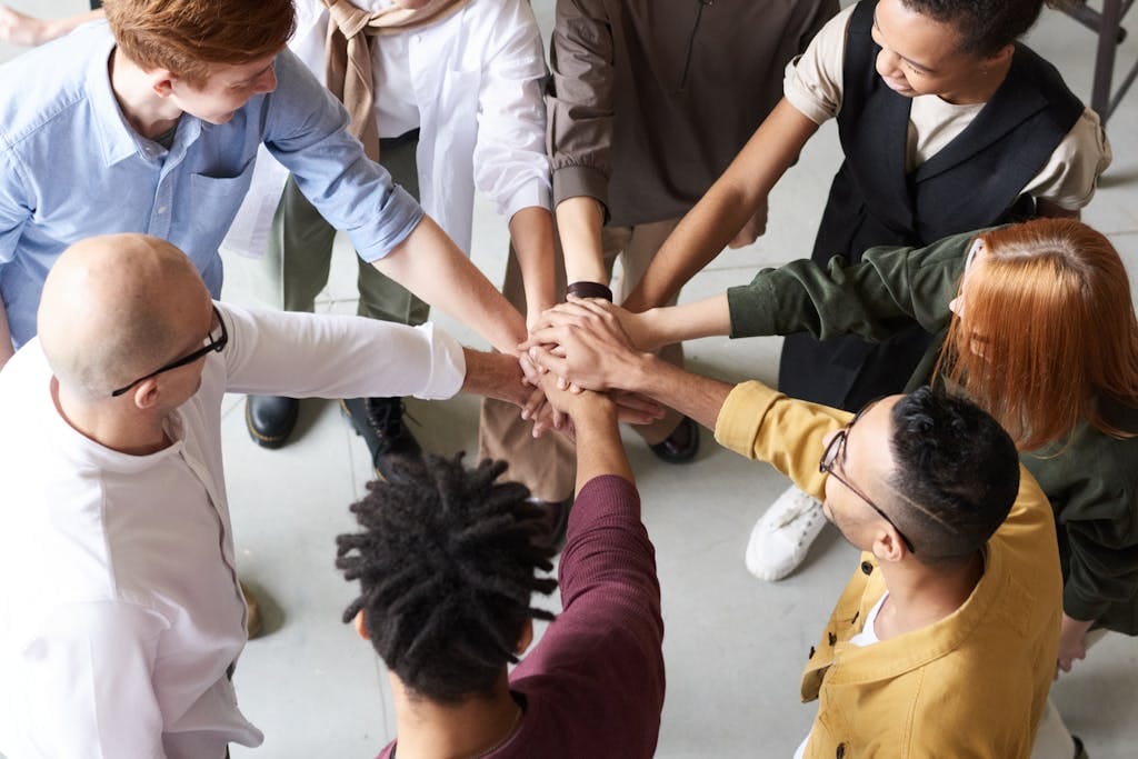 Ein Team legt die Hände übereinander